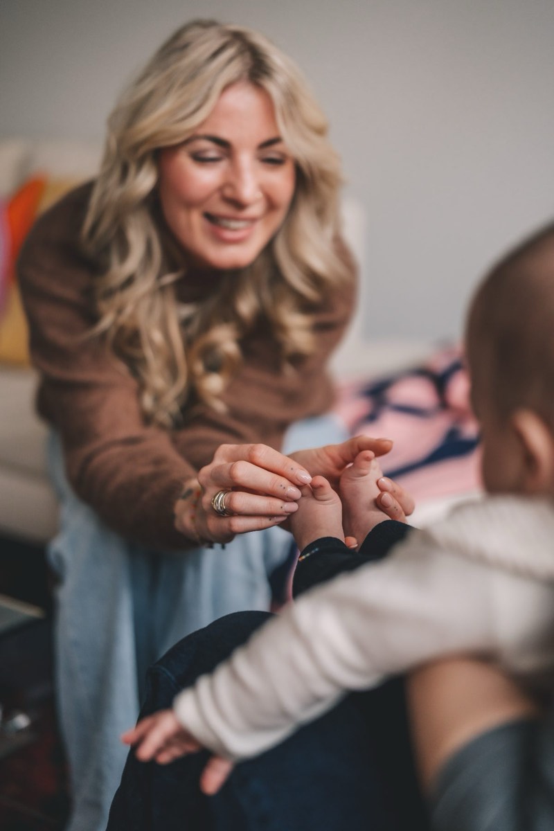 Kira hält die Hände eines Babys